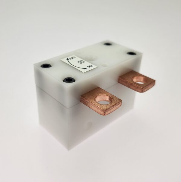 A white block with copper terminals on top of it.